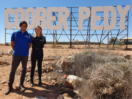 two people stangin by the Coober Pedy sign