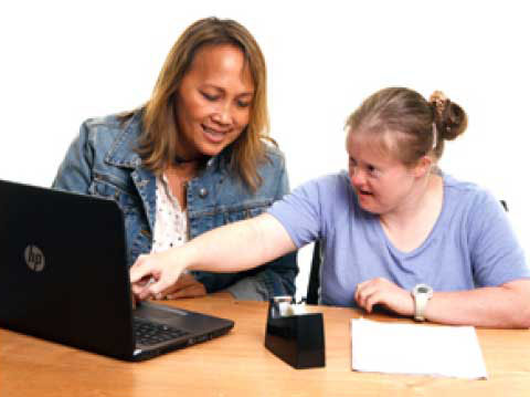 Two women looking at a laptop screen and talking