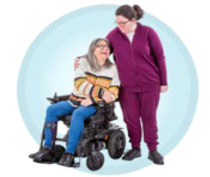 Woman with arm around another woman in a power wheelchair